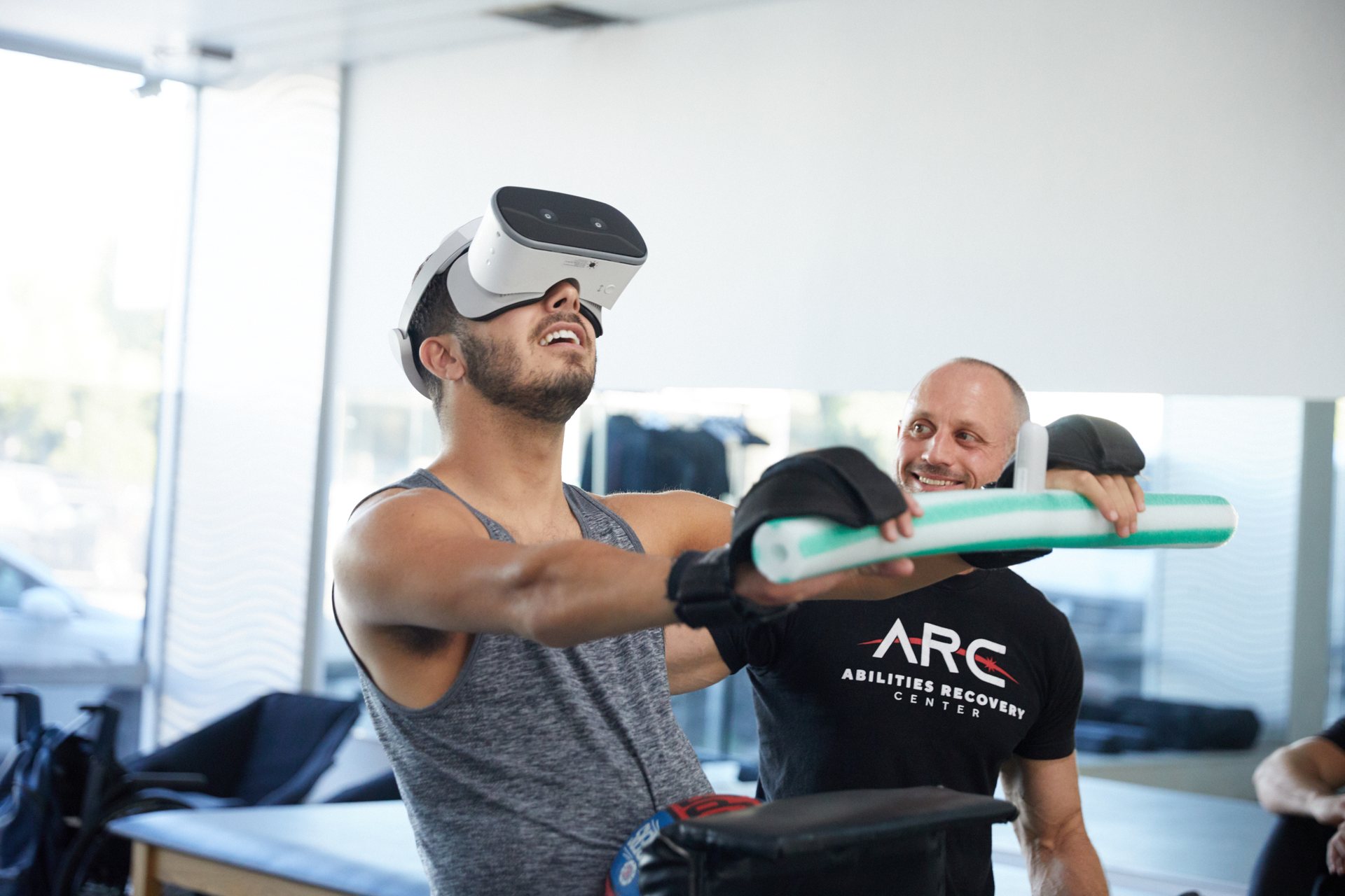 A MIERON user in a VR headset training with a recovery specialist